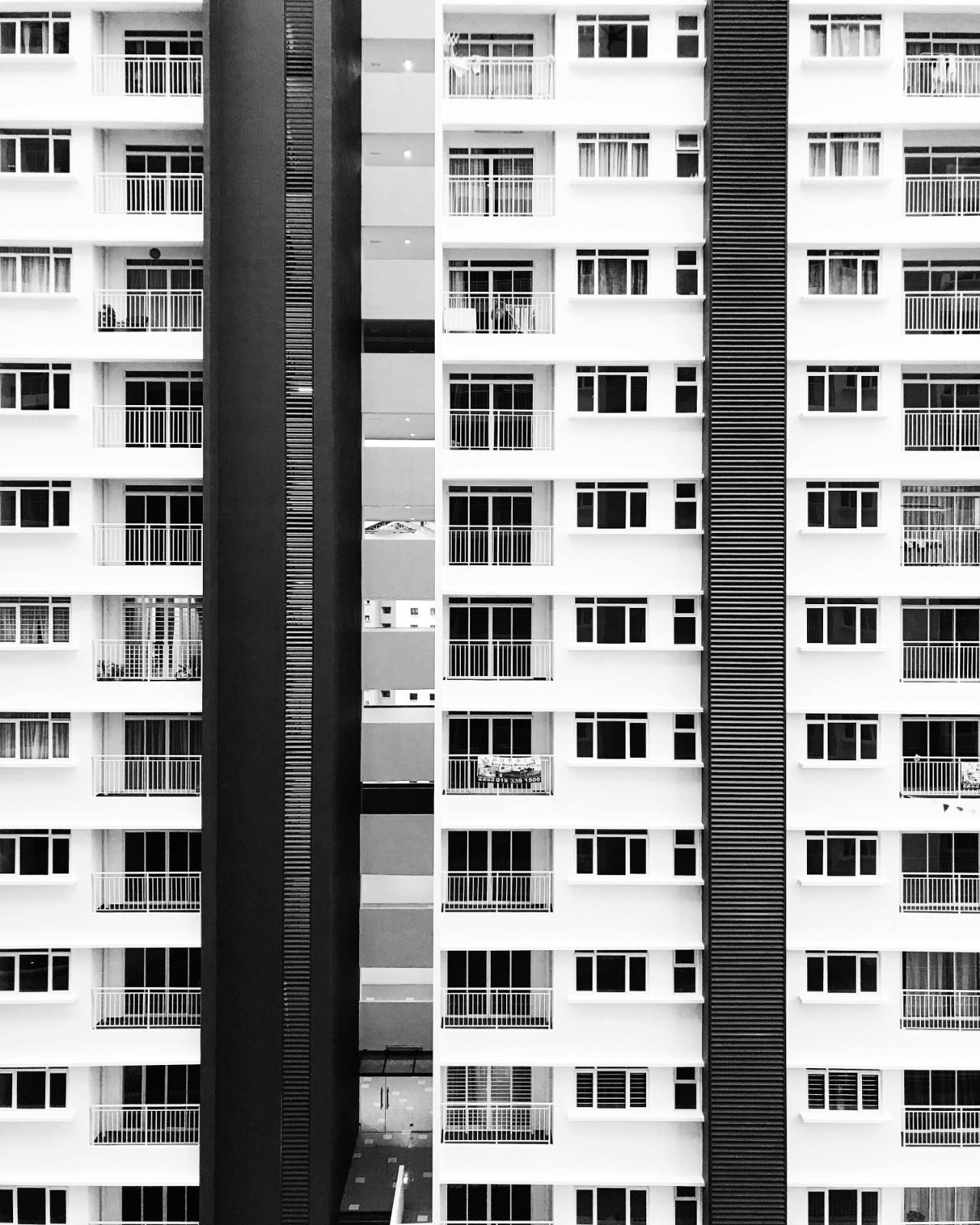 Exterior view of a high-rise residential building with many balconies and units, representing large-scale community management.