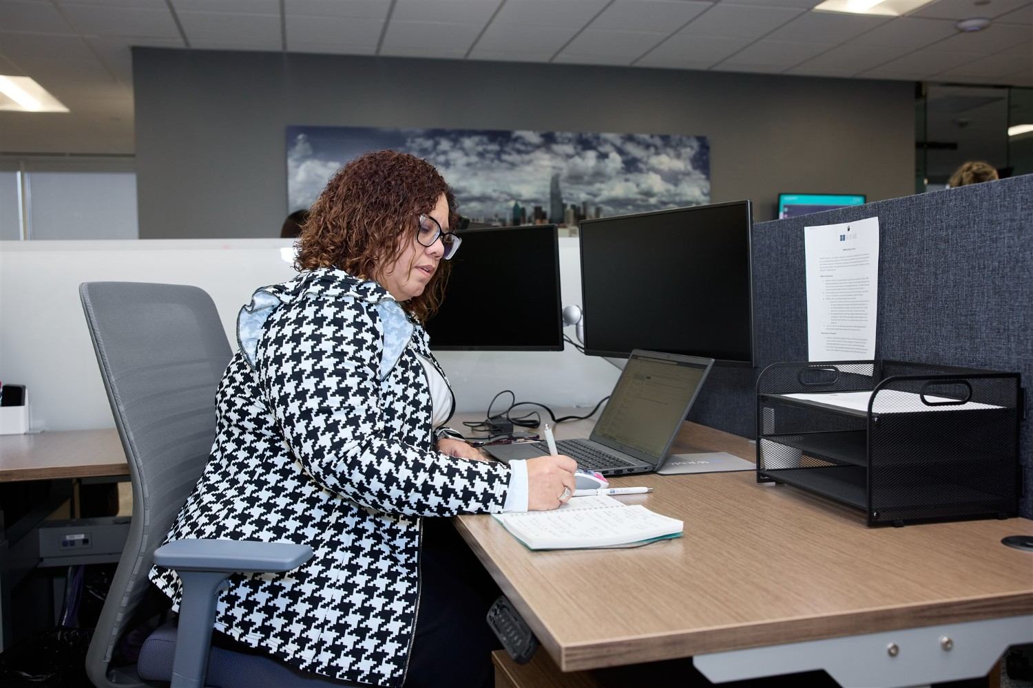 HOA management professional working at a desk in a Frisco office.